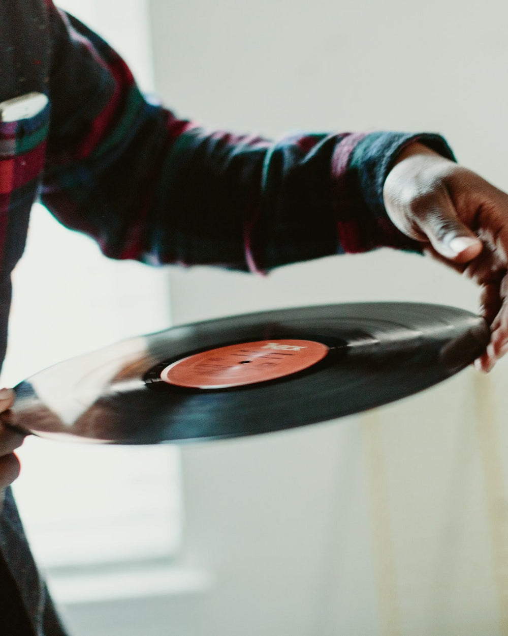 Hands holding a vinyl record by its edges