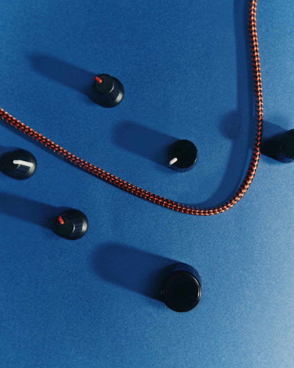Mixer knobs and a braided cable on a blue surface